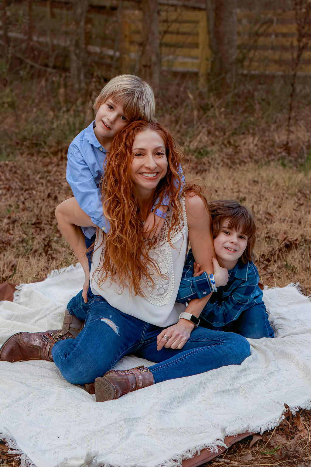 A woman sitting on the ground with two children.